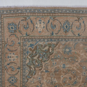 A Close-up of vintage persian rug, Warm brown background with muted blue floral and medallion details. 7.5 x 9.9 feet