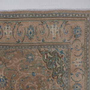 A Close-up of vintage persian rug, Warm brown background with muted blue floral and medallion details. 7.5 x 9.9 feet