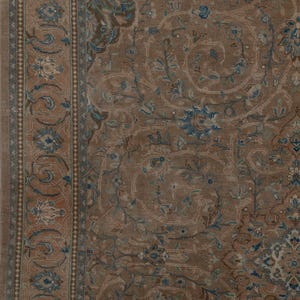 A Close-up of vintage persian rug, Warm brown background with muted blue floral and medallion details. 7.5 x 9.9 feet