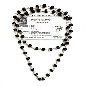 May include: A double-strand necklace with black, spherical beads on a silver chain. The necklace is displayed with a white identification report from a gem testing lab, specifying the beads as natural Karungali, approximately 6 mm.