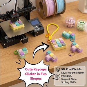 May include: A 3D printer producing a square grid of pastel-colored keycaps, alongside several finished keycap clicker keychains in various shapes and colors. Text on the image reads: Cute Keycaps Clicker in Fun Shapes and STL Print File Info: Layer Height: 0.16mm, Infill: 20%, Support: None, Scaling: 100%.