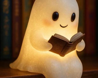 Könnte beinhalten: Eine leuchtende, durchscheinende weiße Geisterfigur mit glatter, glitzernder Textur, runden schwarzen Augen und rosigen Wangen. Der Geist sitzt und hält ein kleines, aufgeschlagenes braunes Buch, das ein warmes, sanftes Licht ausstrahlt.