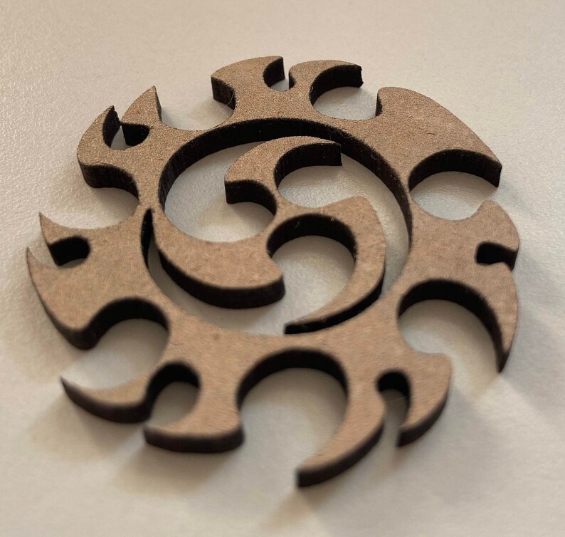 Op de afbeelding: Een bruine houten uitsnijding van een gestileerd abstract ontwerp met een spiraalpatroon.