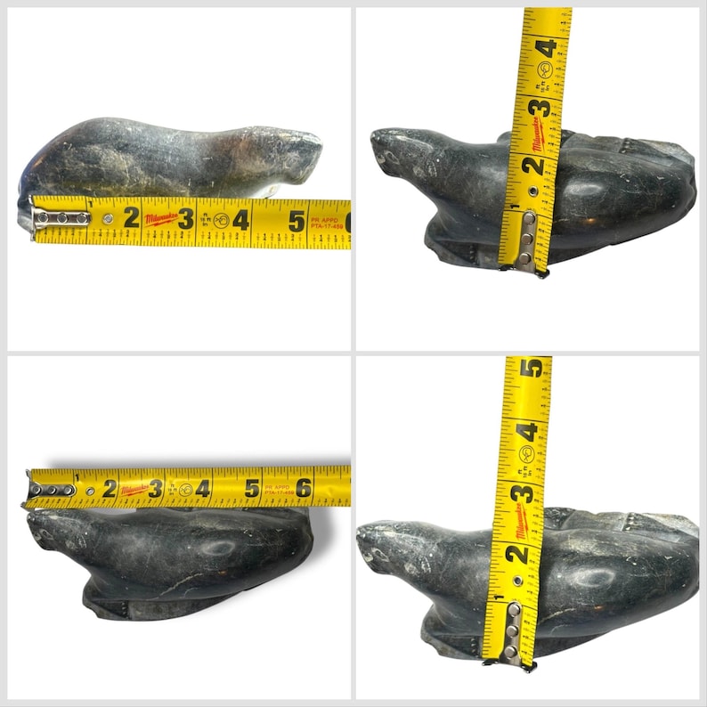 May include: A carved soapstone sculpture of a seal, measuring approximately 6 inches long and 4 inches tall. The sculpture is a dark gray color with a smooth, polished finish.