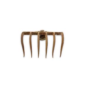 May include: A rusty metal garden rake with five tines. The rake is made of metal and has a brown patina.