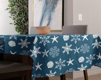 May include: A blue tablecloth with a white snowflake and seashell pattern. The tablecloth is on a table with two chairs and a bowl on the table.