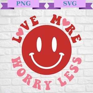 Peut inclure: Un smiley rouge avec des yeux blancs et un sourire, entouré des mots "Love More Worry Less" en rose avec des cœurs.