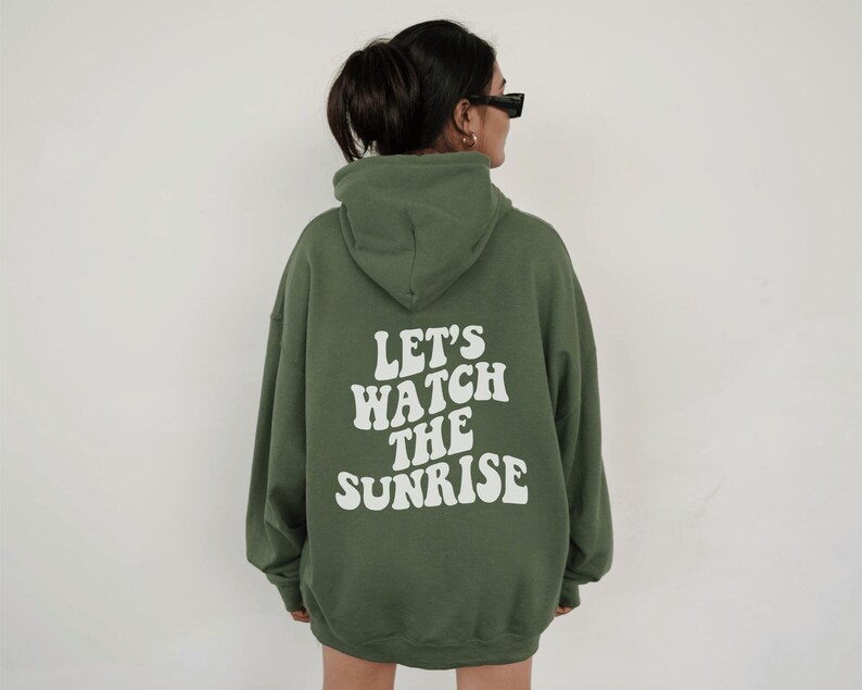 May include: A green hooded sweatshirt with the text "Let's watch the sunrise" printed in white on the back.