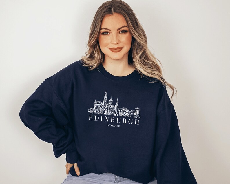 May include: A navy blue sweatshirt with a white graphic of the Edinburgh skyline and the text "EDINBURGH SCOTLAND".