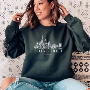 May include: A dark green sweatshirt with a white graphic of the Edinburgh skyline and the text "EDINBURGH SCOTLAND".
