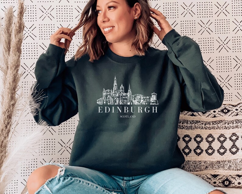 May include: A dark green sweatshirt with a white graphic of the Edinburgh skyline and the text "EDINBURGH SCOTLAND".
