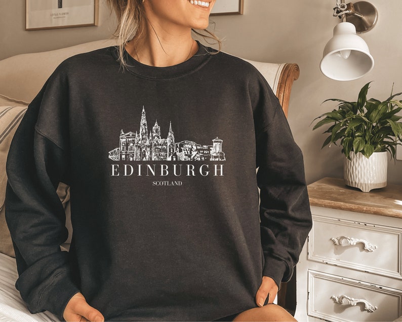 May include: Black sweatshirt with a white graphic of the Edinburgh skyline and the text "EDINBURGH SCOTLAND".