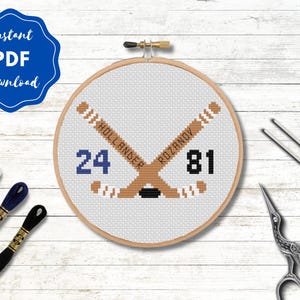 May include: Cross-stitch hockey design in a wooden hoop. The design features crossed hockey sticks, player numbers 24 and 81, and the names Hollander and Rozanov. The words "Instant PDF Download" are in a blue circle.