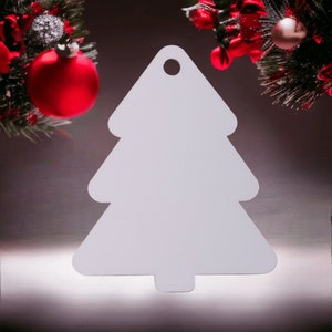 May include: White paper Christmas tree ornament with a hole at the top for hanging. The ornament is shaped like a traditional Christmas tree with a pointed top and a wide base.