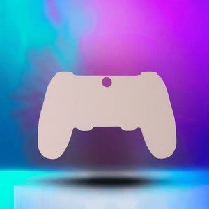 May include: White plastic cutout of a video game controller. The controller is a simple silhouette with no details.