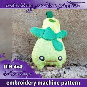Puede incluir: Patrón de máquina de bordado para un juguete de peluche en forma de pera verde con una hoja verde en la parte superior y una cara linda. El patrón es para un aro de 4x4 pulgadas y está etiquetado como "ITH 4x4 in the hoop".