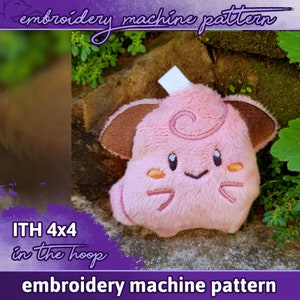 May include: Pink and brown plush toy with embroidered details, resembling a cartoon character. The toy is labeled "ITH 4x4 in the hoop" and "embroidery machine pattern".