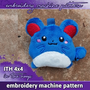 May include: Blue and white plush toy with red ears, embroidered with a cute face. The toy is labelled "ITH 4x4 in the hoop embroidery machine pattern".