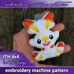 Puede incluir: Un personaje de peluche blanco y naranja con detalles bordados, incluyendo una boca rosa y ojos negros. La imagen incluye el texto "embroidery machine pattern" y "ITH 4x4 in the hoop".