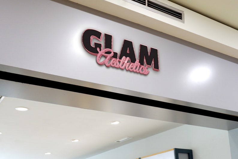 May include: A shopfront sign with the text "GLAM Aesthetics" in black and pink 3D lettering.