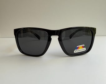 Gafas de sol polarizadas cuadradas negras brillantes de diseño para hombre con detalles metálicos en las patillas.