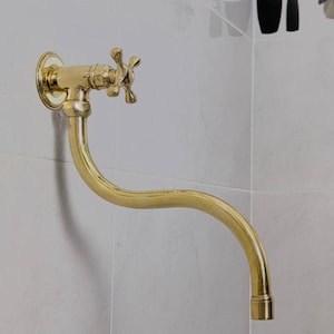 Unalquered Brass Wall-Mounted Pot Filler Faucet With Swivel Spout.