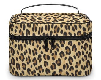 May include: A rectangular makeup bag with a black zipper and handle. The bag is covered in a leopard print pattern with brown and black spots on a tan background. The bag has a black zipper and a black handle.