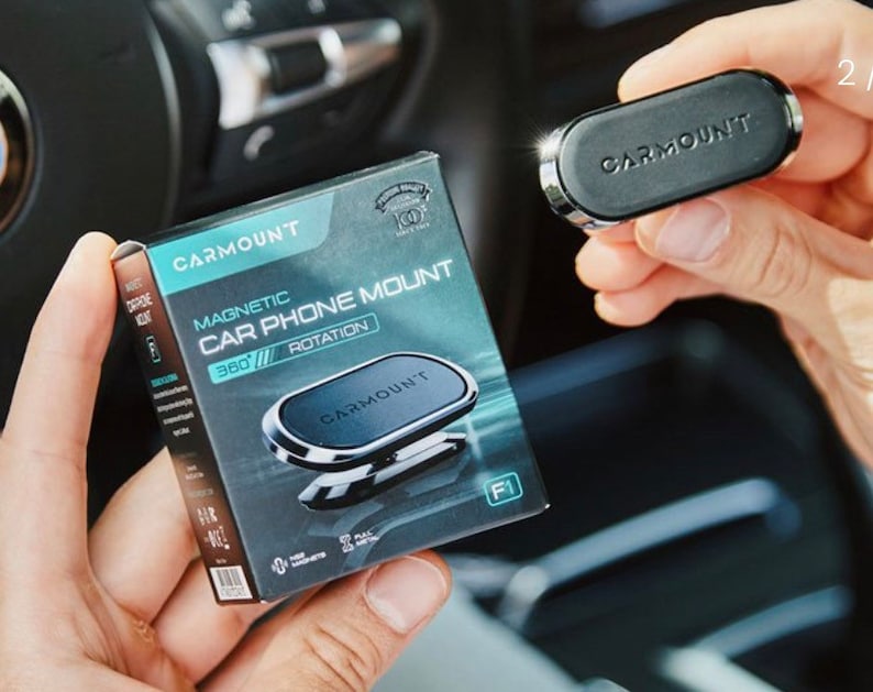 May include: A black magnetic car phone mount with a 360 degree rotation. The mount is made by CarMount and is shown in a close-up view.