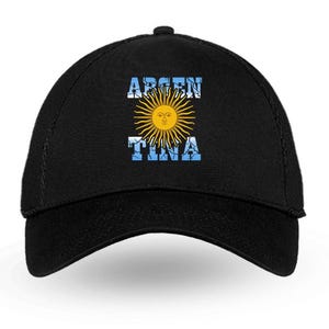 May include: Black baseball cap featuring the word "ARGENTINA" in white, with a yellow sun design in the center. The sun has a face and is surrounded by rays. The background of the text is blue.