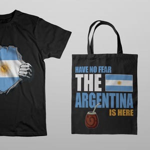 May include: A black t-shirt, tote bag, and mug featuring the Argentinian flag. The t-shirt design shows the flag bursting through a ripped shirt. The tote bag has the text "Have No Fear The Argentina Is Here". The mug has the flag and text.