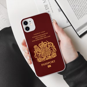 Peut inclure: Une coque de t&eacute;l&eacute;phone iPhone rouge et blanche avec un design dor&eacute; du blason royal britannique et le texte "EUROPEAN UNION UNITED KINGDOM OF GREAT BRITAIN AND NORTHERN IRELAND PASSPORT".