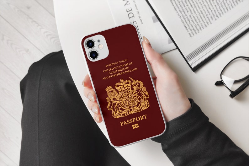 Peut inclure: Une coque de t&eacute;l&eacute;phone iPhone rouge et blanche avec un design dor&eacute; du blason royal britannique et le texte "EUROPEAN UNION UNITED KINGDOM OF GREAT BRITAIN AND NORTHERN IRELAND PASSPORT".