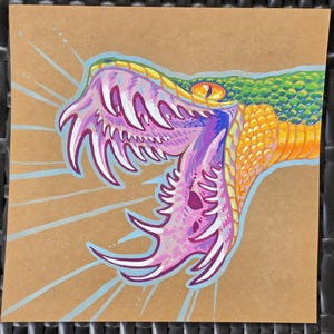 May include: A colorful illustration of a snake's open mouth, showcasing sharp white fangs and a vibrant palette. The artwork features shades of green, yellow, orange, purple, and pink, set against a brown background with light blue lines radiating outwards.