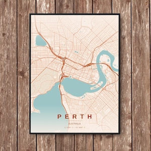 Puede incluir: Una impresión enmarcada del mapa de Perth, Australia, con una red detallada de calles y carreteras en tonos marrones y beige. El mapa incluye un río y un lago azul verdoso, con el nombre de la ciudad y las coordenadas en la parte inferior.