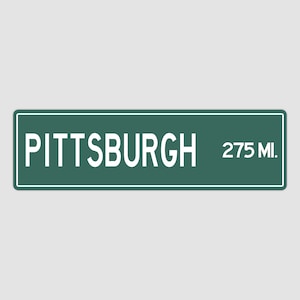 May include: Green road sign with white text that reads "PITTSBURGH 275 MI."