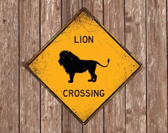 Może przedstawiać: Zniszczony, żółty znak w kształcie rombu z czarnym napisem "LION CROSSING". Czarna sylwetka lwa znajduje się na środku. Znak jest zamontowany na drewnianym tle, tworząc rustykalną estetykę.
