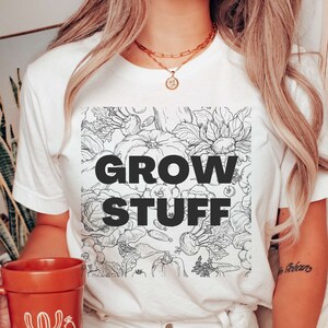 May include: White t-shirt with a black and white illustration of vegetables and the text "GROW STUFF" printed on the front.
