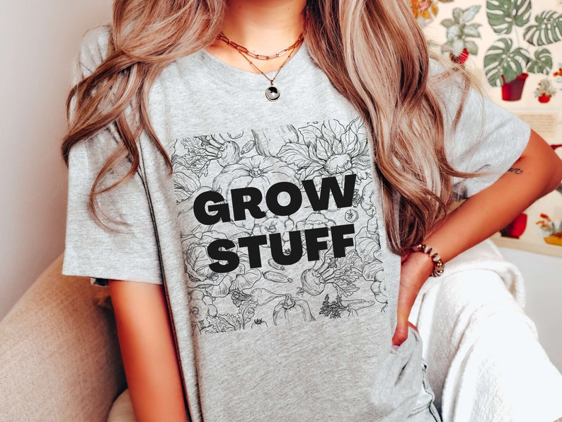 May include: Gray t-shirt with a black and white floral design and the text "GROW STUFF" printed on the front.