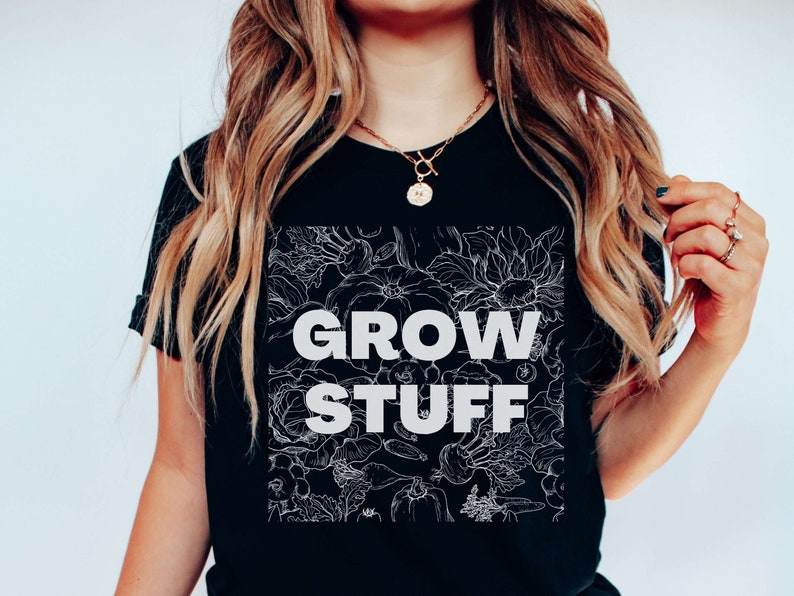 May include: Black t-shirt with a white floral design and the text "GROW STUFF" in white.