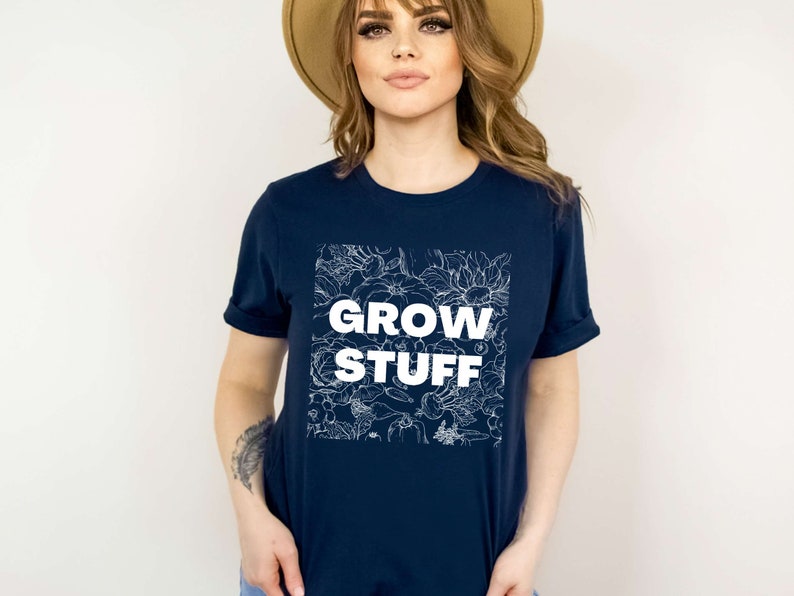 May include: A navy blue t-shirt with a white floral design and the text "GROW STUFF" in white.