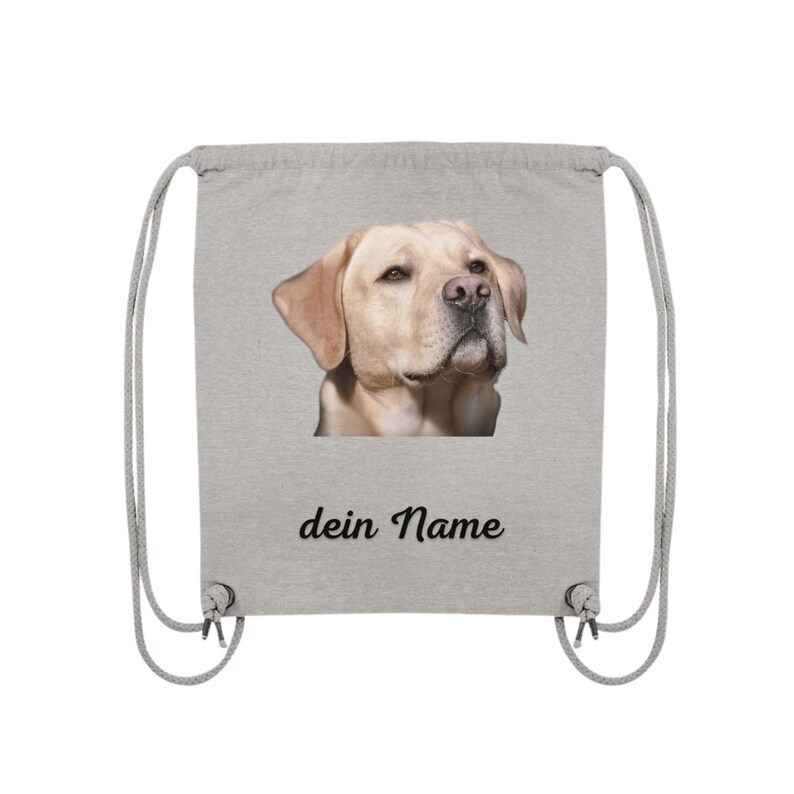 May include: A gray drawstring bag with a picture of a golden retriever dog on the front. The bag has the text "dein Name" printed below the image.