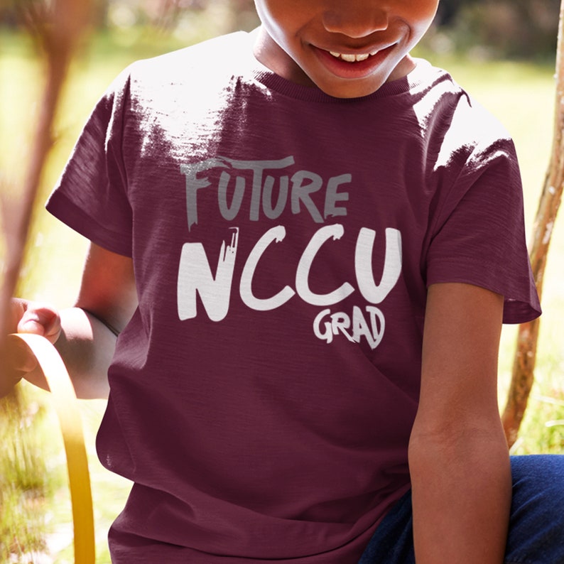 May include: A maroon t-shirt with white text that reads "Future NCCU Grad".