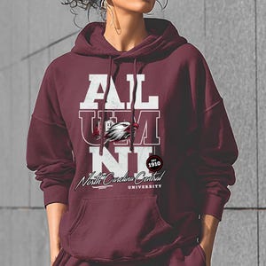 May include: Maroon hoodie with the word "ALUMNI" in white block letters. The hoodie features a graphic of an eagle and the text "North Carolina Central University" in script. The year "1910" is also displayed.