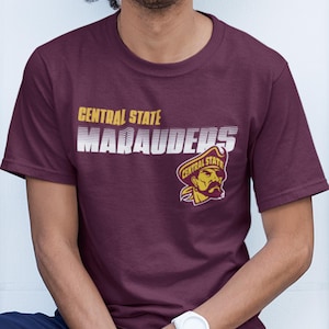 May include: A maroon t-shirt with a white graphic that says "Central State Marauders" and a yellow mascot logo.