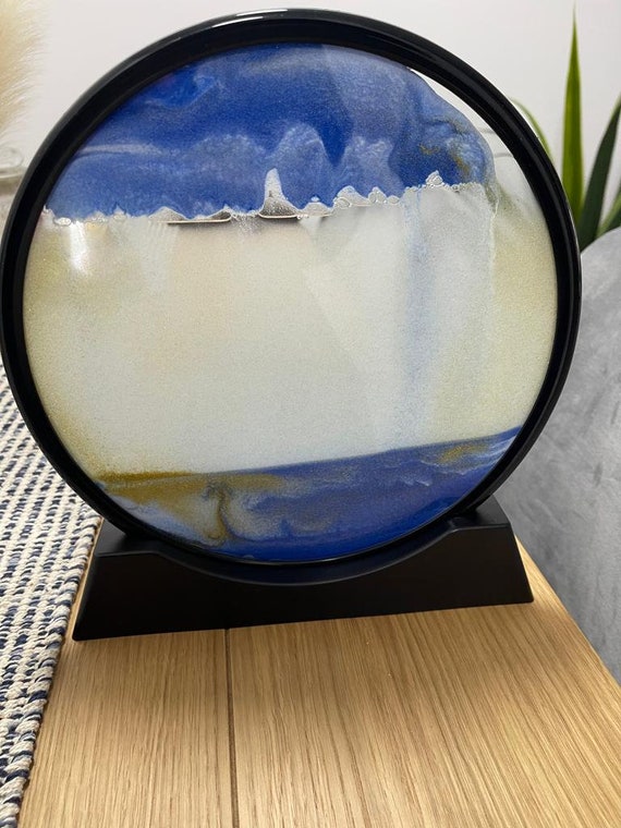 A round, framed hourglass where shifting colored sands form ever-changing deep-sea landscapes — mesmerizing desk therapy you never have to wind up.