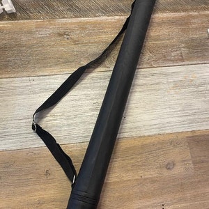 May include: A black canvas tube with a shoulder strap for carrying rolled up posters or prints.