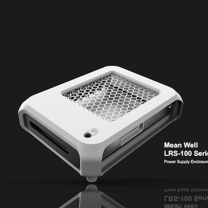 Op de afbeelding: Een wit en grijs Mean Well LRS-100 Series voedingbehuizing. Het apparaat heeft een honingraat mesh bovenkant en een strak, modern design. Het product staat tegen een donkere achtergrond.