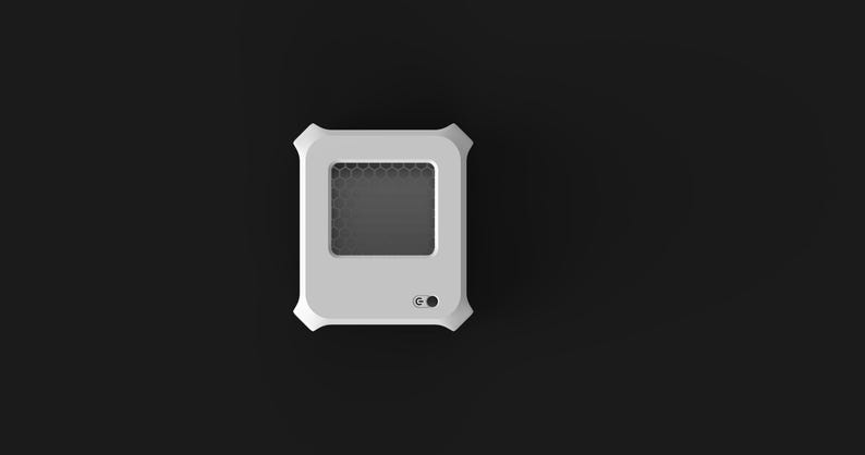Peut inclure: Un appareil rectangulaire blanc avec des coins arrondis et un &eacute;cran gris fonc&eacute; avec un motif en nid d'abeille. Un petit bouton et un voyant lumineux sont visibles en bas. L'appareil est pos&eacute; sur un fond noir.