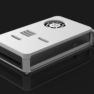 May include: A white and black rectangular electronic device with a rounded frame. The top has ventilation holes and slots. The device is on a reflective black surface.