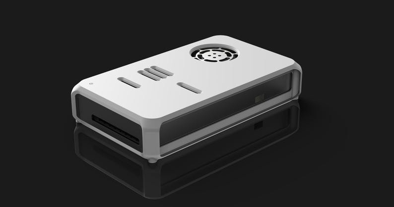 May include: A white and black rectangular electronic device with a rounded frame. The top has ventilation holes and slots. The device is on a reflective black surface.